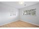 Neutral bedroom with two bright windows and light hardwood floors at 39035 Citadel Cir, Zephyrhills, FL 33542