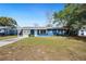 Charming blue single-story home featuring a long driveway, front lawn, and attached single-car garage at 39035 Citadel Cir, Zephyrhills, FL 33542