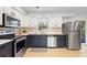 Well-lit kitchen with stainless steel appliances, dark lower cabinets, and light countertops at 39035 Citadel Cir, Zephyrhills, FL 33542