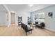 Bright living room featuring light hardwood floors, large window, and stylish seating at 39035 Citadel Cir, Zephyrhills, FL 33542