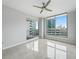 Bright bedroom features a ceiling fan, tile flooring, balcony access, and impressive city views through expansive windows at 449 S 12Th St # 1105, Tampa, FL 33602