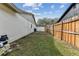 A view of the backyard, featuring a wooden fence, lawn, and neighboring houses at 4504 Grainary Ave, Tampa, FL 33624