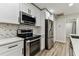 Modern kitchen with stainless steel appliances, white cabinets, and attractive backsplash detail at 4504 Grainary Ave, Tampa, FL 33624