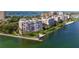 Breathtaking aerial view highlighting the condo building, waterfront access, and stunning coastal scenery at 4993 Bacopa S Ln # 304, St Petersburg, FL 33715