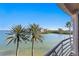 Stunning balcony view featuring palm trees, tranquil bay waters, and a clear blue sky at 4993 Bacopa S Ln # 304, St Petersburg, FL 33715