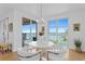 Bright dining area featuring modern white furniture and expansive water view at 4993 Bacopa S Ln # 304, St Petersburg, FL 33715