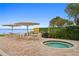 Outdoor seating area with a hot tub and umbrellas overlooking the ocean at 4993 Bacopa S Ln # 304, St Petersburg, FL 33715