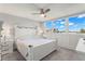 Bright bedroom with white furniture, ceiling fan and a view of the city through the windows at 500 Treasure Island Cswy # 404, Treasure Island, FL 33706