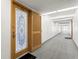 Long, carpeted hallway leading to unit 404, featuring a decorative glass door and an adjacent louvered door at 500 Treasure Island Cswy # 404, Treasure Island, FL 33706