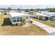 Aerial view of the charming manufactured home with a covered parking area and landscaped yard at 5238 Mary St, Zephyrhills, FL 33542