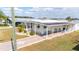 Inviting manufactured home with a covered parking area, front porch, and well-maintained lawn at 5238 Mary St, Zephyrhills, FL 33542