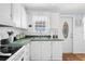 Cozy kitchen features white cabinets, light countertops, stainless steel sink and a charming window at 5238 Mary St, Zephyrhills, FL 33542