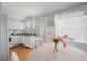 Bright eat-in kitchen featuring white cabinets, a stainless steel sink, and a charming dining area at 5238 Mary St, Zephyrhills, FL 33542