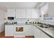 Bright kitchen with white appliances, cabinets, and a stainless steel sink with a view from the window at 5238 Mary St, Zephyrhills, FL 33542