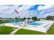 Aerial view of a fenced community pool with blue umbrellas and lounge chairs at 5238 Mary St, Zephyrhills, FL 33542