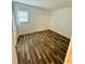 An empty bedroom with wood-look flooring has neutral walls and a window at 5627 Ashley Oaks Dr # 4, Tampa, FL 33617