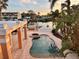 Beautiful backyard pool with water views, tropical plants, and surrounding patio at 567 Baywood S Dr, Dunedin, FL 34698