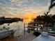 Beautiful backyard view overlooking tranquil canal and boat docks at sunset at 567 Baywood S Dr, Dunedin, FL 34698