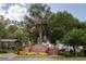 Welcoming Edgewater Park entrance featuring lush landscaping, mature trees, and well-maintained brick signage at 567 Baywood S Dr, Dunedin, FL 34698