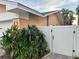 View of the home's side yard with privacy fence and painted fruit near the garage at 567 Baywood S Dr, Dunedin, FL 34698