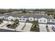 Aerial view of stylish townhomes near a scenic pond, featuring landscaping and community parking at 6256 Shiner St, Land O Lakes, FL 34638