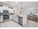 Modern white kitchen with stainless steel appliances and open floor plan concept to living area at 6256 Shiner St, Land O Lakes, FL 34638