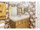 Bathroom featuring a sink and vanity with decorative floral wallpaper at 7301 Avocet Dr, Wesley Chapel, FL 33544