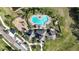 Aerial view showcases the community pool, playground, and clubhouse surrounded by lush landscaping at 7324 Steer Blade Dr, Zephyrhills, FL 33541