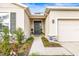 Inviting front entrance with a black front door, stone accents, and meticulously landscaped walkway at 7324 Steer Blade Dr, Zephyrhills, FL 33541