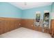 Bedroom with blue walls, tiled floors, and window views, currently under renovation with exposed wall framing at 7623 Mako Dr, Hudson, FL 34667