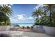 Scenic poolside view with lounge chairs, palm trees, and ocean backdrop, providing a tranquil and luxurious resort experience at 805 S Gulfview Blvd # 504B, Clearwater, FL 33767