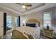 Bedroom with tray ceiling, ceiling fan, shutters, and french doors leading to patio at 817 Wilkie St, Dunedin, FL 34698