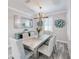 Elegant dining room with a rustic wood table, stylish chandelier, and neutral decor at 817 Wilkie St, Dunedin, FL 34698