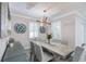 Bright dining room features modern chandelier, table with seating for six, and decorative wall art at 817 Wilkie St, Dunedin, FL 34698