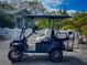 A blue onward golf cart with white seats is parked on a brick road at 817 Wilkie St, Dunedin, FL 34698