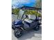 A blue onward golf cart with white seats parked on a brick road at 817 Wilkie St, Dunedin, FL 34698