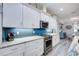 Modern kitchen with white cabinetry, stainless steel appliances, and a blue tile backsplash at 817 Wilkie St, Dunedin, FL 34698