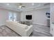 Modern living room featuring gray floors, white couch, and a mounted TV at 817 Wilkie St, Dunedin, FL 34698