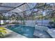 Beautiful screened-in pool area with a waterfall feature and lush landscaping, perfect for relaxation and entertainment at 817 Wilkie St, Dunedin, FL 34698