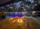 Beautiful pool with lighting in screened-in enclosure. Fire pit and outdoor seating at 817 Wilkie St, Dunedin, FL 34698