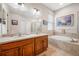 Bright bathroom with dual sinks, a soaking tub, and a glass-enclosed shower at 833 Seminole Sky Dr, Ruskin, FL 33570