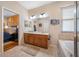 Bathroom featuring dual vanities, a large mirror and a luxurious soaking tub at 833 Seminole Sky Dr, Ruskin, FL 33570