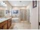 Bathroom featuring dual sinks, soaking tub, and glass-enclosed shower, all with neutral tones at 833 Seminole Sky Dr, Ruskin, FL 33570