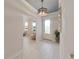 Bright hallway with decorative lighting fixture, white walls, and light-colored wood floors leading to the front door at 9273 Highland Hills Dr, Hudson, FL 34667