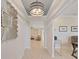 Bright hallway with decorative lighting fixture, white walls, and light-colored wood floors, leading to other rooms at 9273 Highland Hills Dr, Hudson, FL 34667