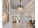 Bright hallway with decorative lighting fixture, white walls, and light-colored wood floors leading to the dining room at 9273 Highland Hills Dr, Hudson, FL 34667