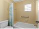 Bright bathroom features a bathtub with shower and grab bar at 1706 Belleair Forest Dr # 348, Belleair, FL 33756