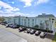 Exterior view of a condo building with ample parking and a commercial vehicle at 1706 Belleair Forest Dr # 348, Belleair, FL 33756