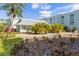 Beautifully landscaped grounds with walkway, tropical plants, and benches under the palm trees at 1706 Belleair Forest Dr # 348, Belleair, FL 33756