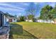 Grassy backyard with mature trees and a view of the back of the main house and the shed at 1016 Mandalay Dr, Brandon, FL 33511